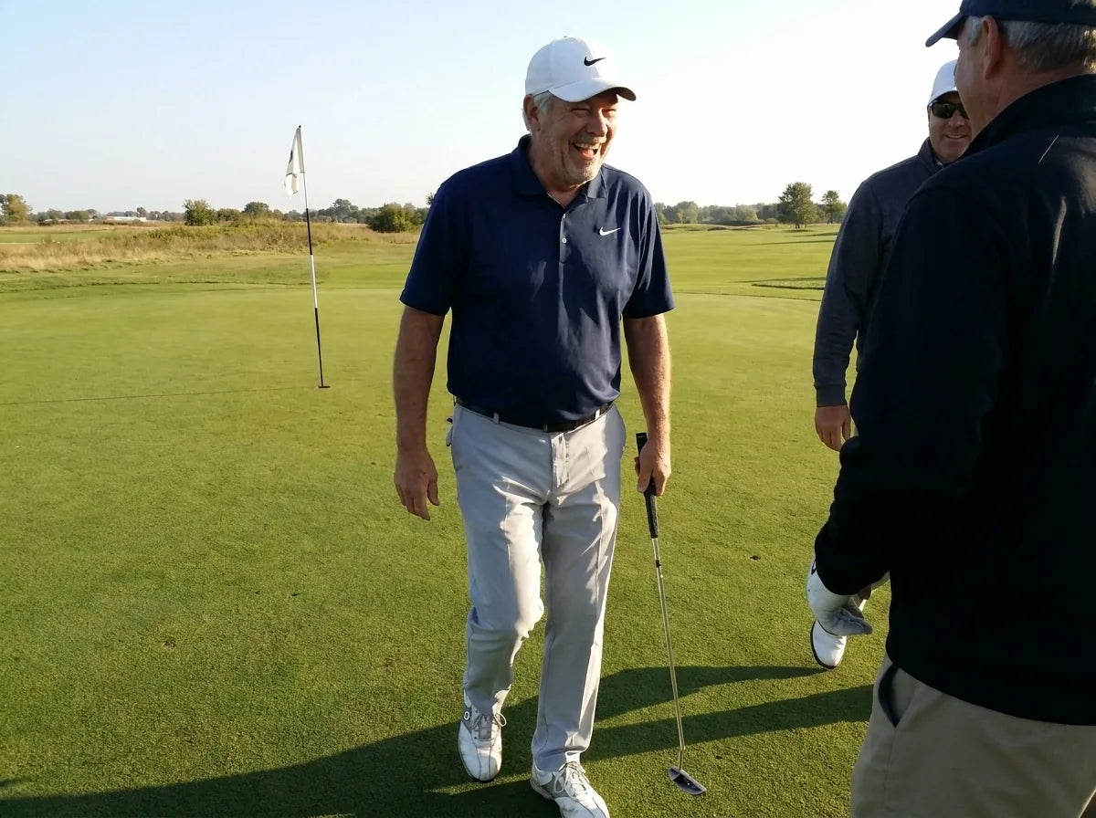The same golfer laughing with his buddies as they walk off the 18th green